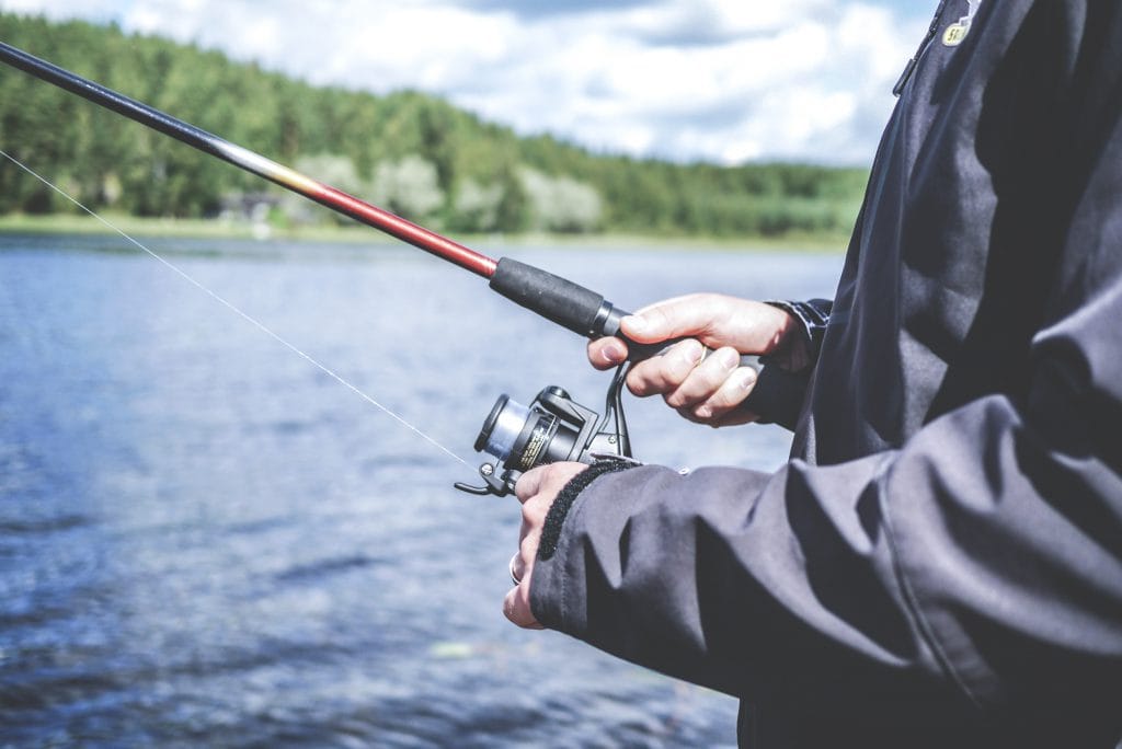 fishing lake reeling in catching fish jacket windy windbreaker