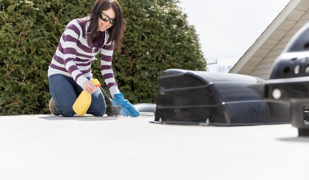 a girl cleaning the roof of a trailer