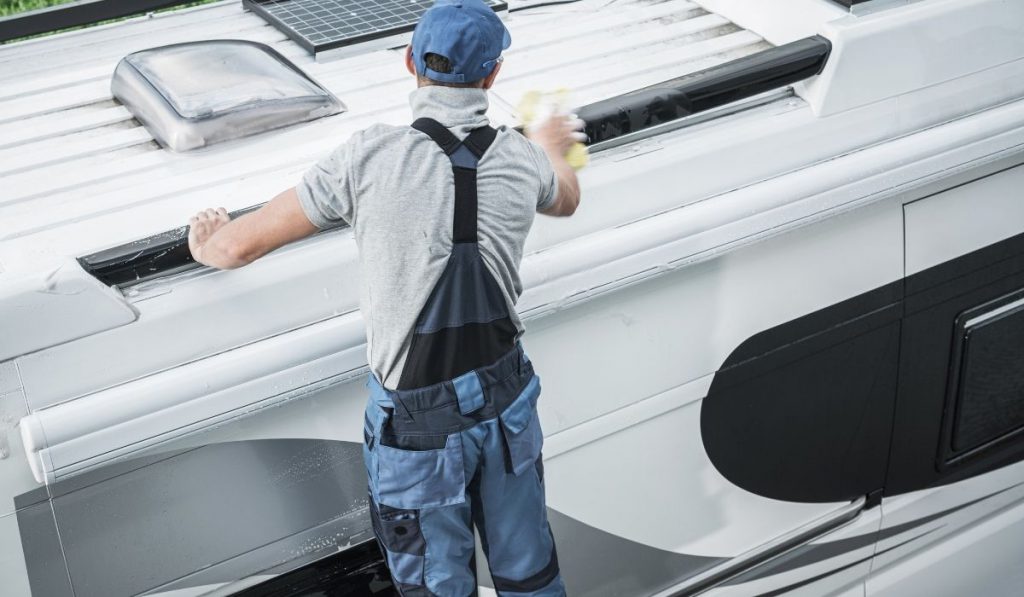 man cleaning and maintaining an RV